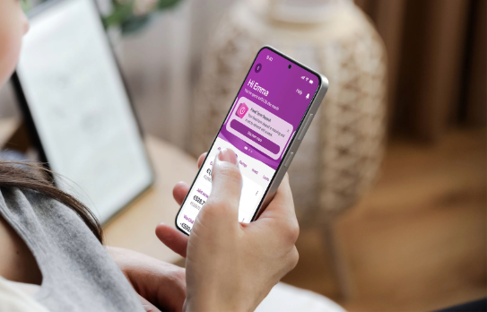 Woman holding a smartphone showing the accounts screen of the new mobile app